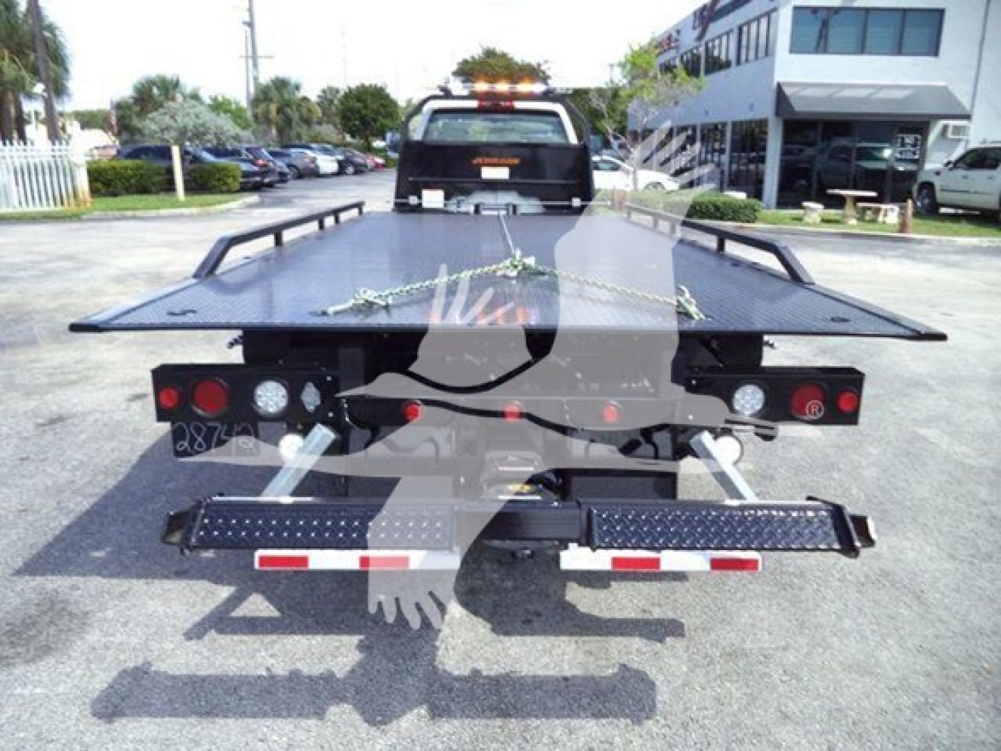 Tow truck flatbed rollback showing rear platform with lights and safety rails.