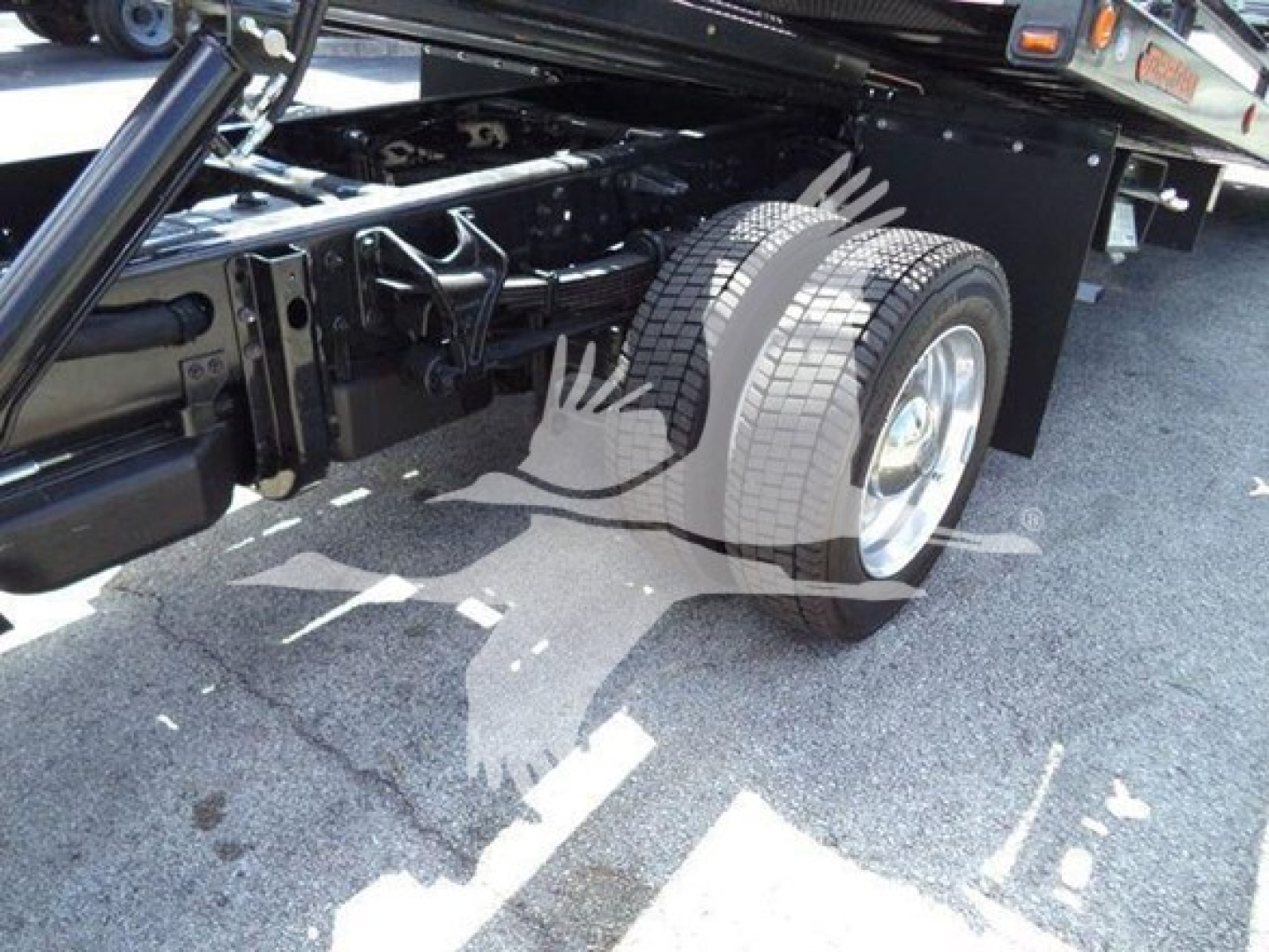 Rear dual rear axle and suspension on a 2023 International CV rollback truck showing tires and undercarriage components.
