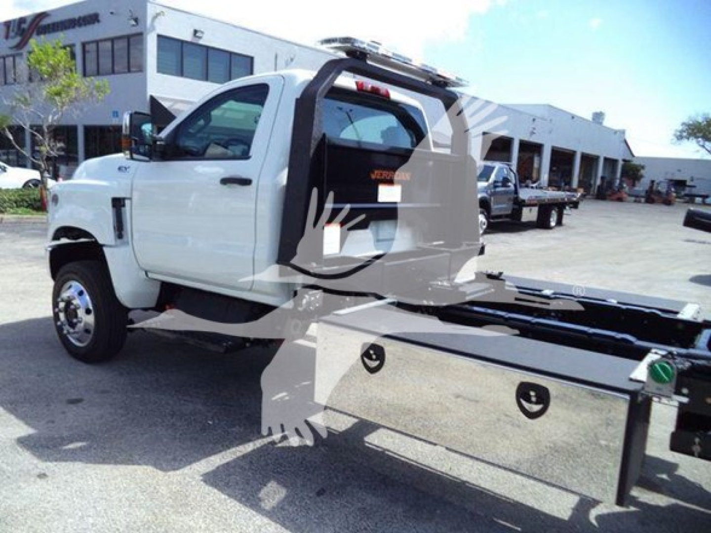 White International CV rollback tow truck side view showing flatbed, cab with open door, and hydraulic equipment.
