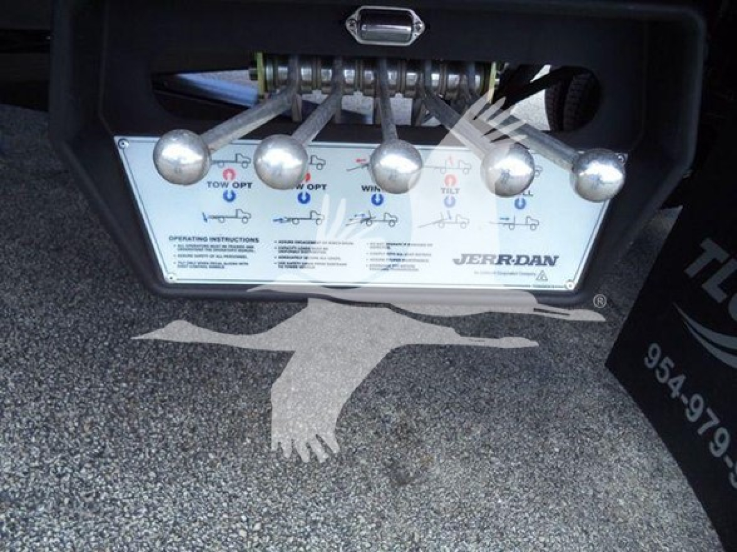 Control panel of a Jerr-Dan rollback tow truck showing five valve levers and operating instructions plate with logos and text.