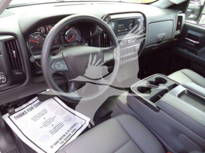 Interior of a new 2023 International CV truck showing steering wheel, instrument cluster, center console with touchscreen, and driver seat with paperwork on the floor.