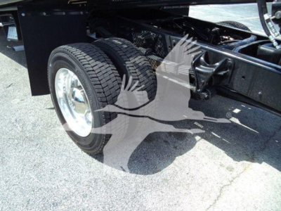 Dual rear wheels and chassis components of a new International CV rollback truck, with visible tires and undercarriage.