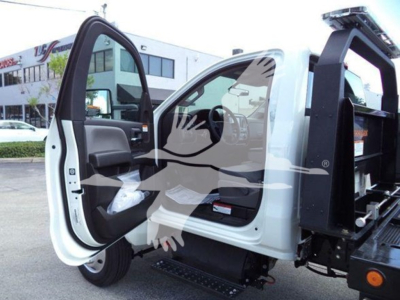 Truck cab interior with open door showing steering wheel and dashboard; white exterior; rollback equipment in bed; VIN and stock info not visible on image.