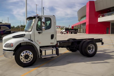 Freightliner M2 106 Plus cab with chassis showing front wheel, cab door, and chassis frame.
