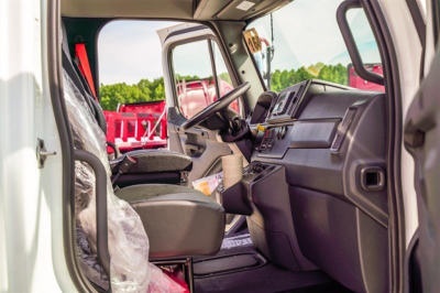 Cab and chassis truck interior showing steering wheel, dashboard, and driver seat in a new Freightliner M2 106 Plus.