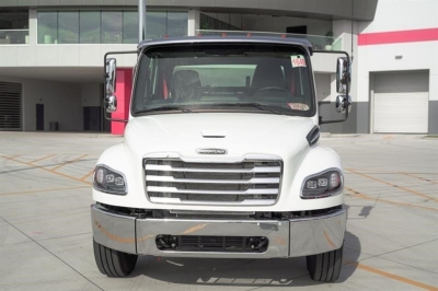 Front view of a white Freightliner M2 106 Plus cab and chassis truck showing chrome bumper, grille, and side mirrors.