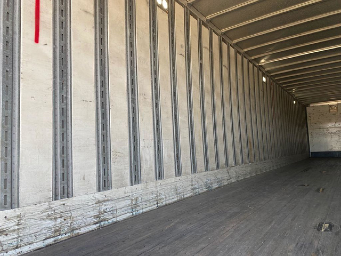 Interior of a 2014 Stoughton van trailer with metal side walls and wooden floor, long empty cargo area.