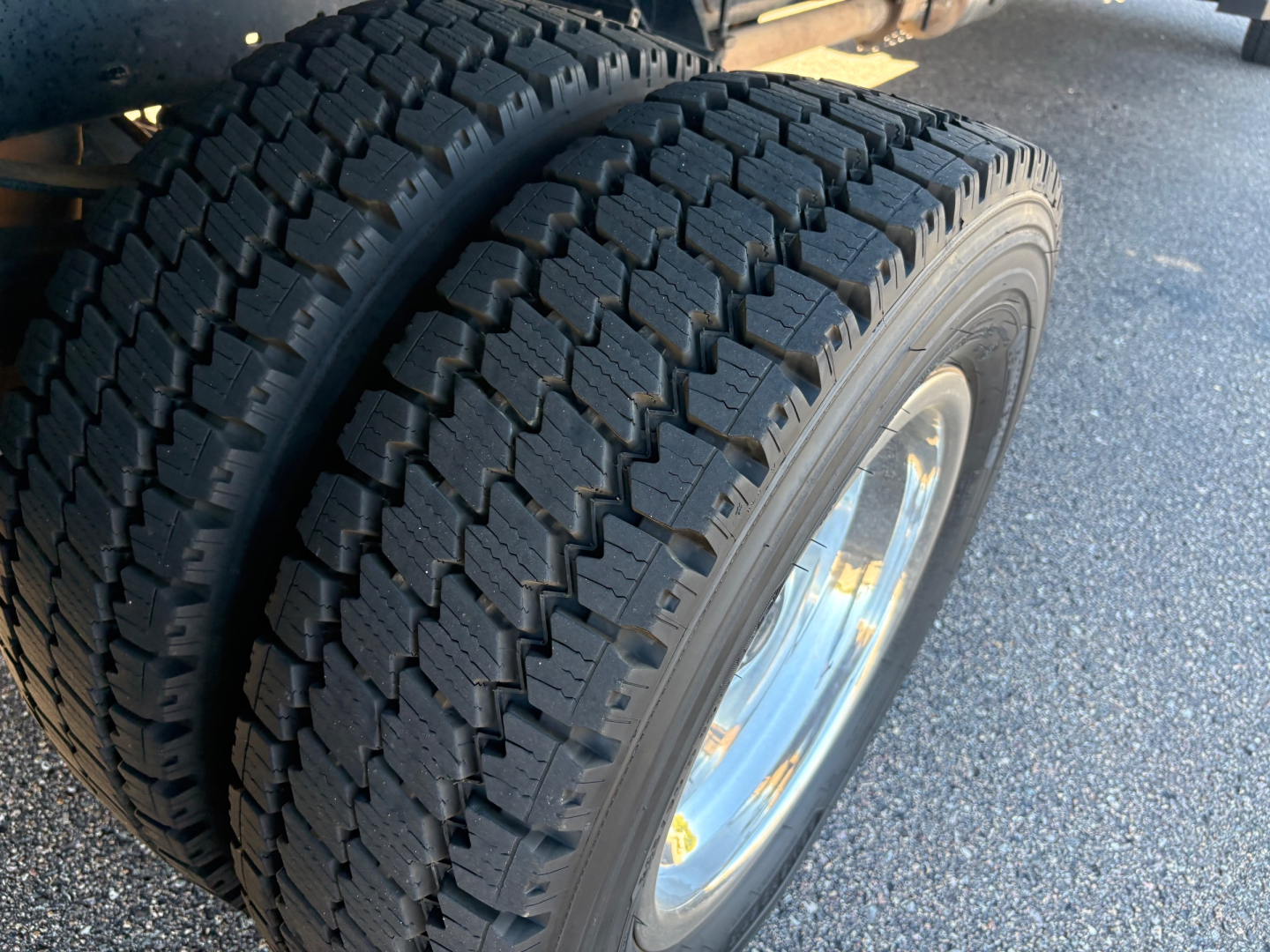 Dual rear tires on a Ford F-550 chassis showing tread pattern and wheel rim, part of a box truck configuration.