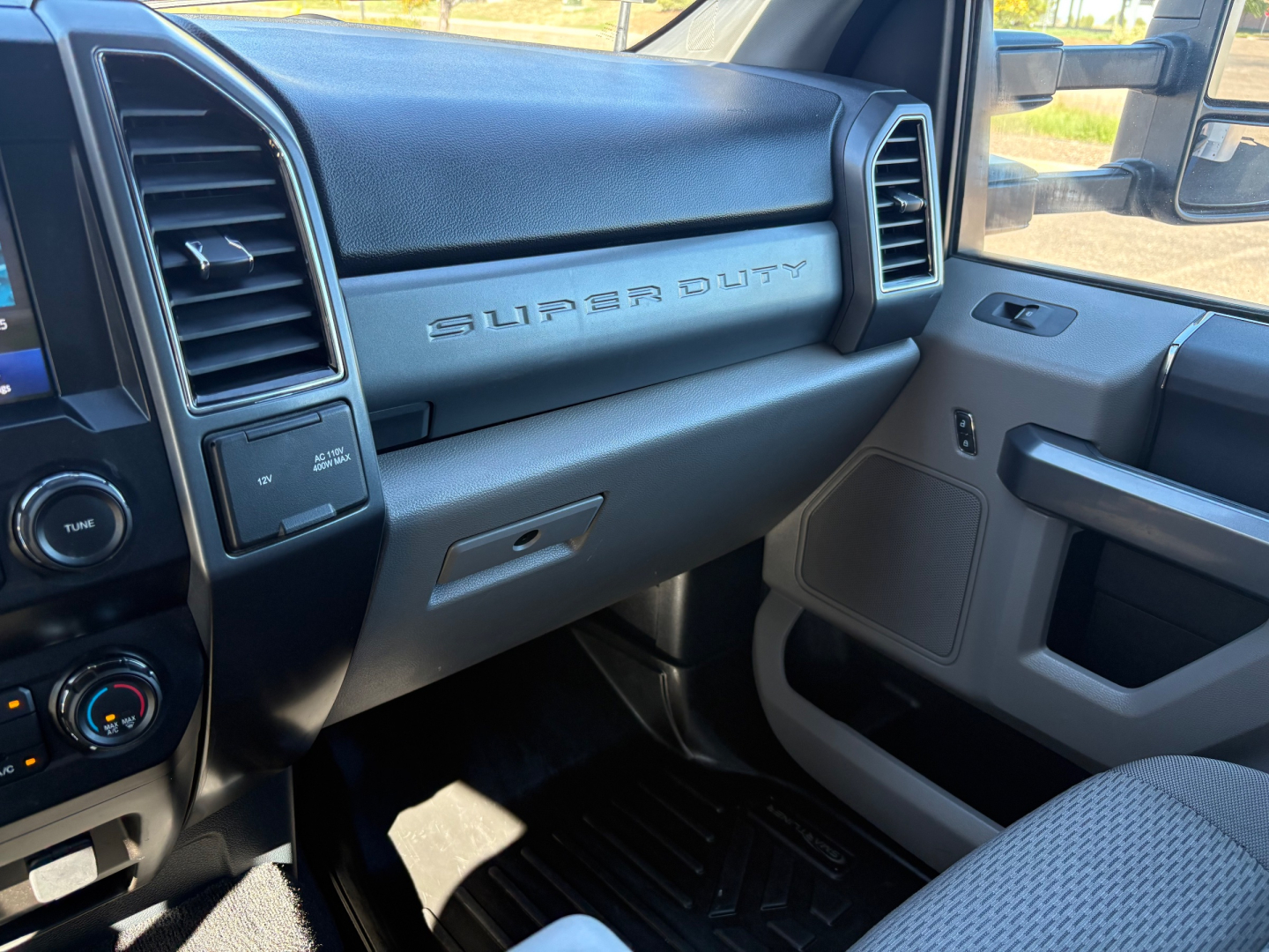 Ford Super Duty F-550 interior dashboard view showing 'SUPER DUTY' badge on passenger side and center console, with steering wheel area and HVAC controls.