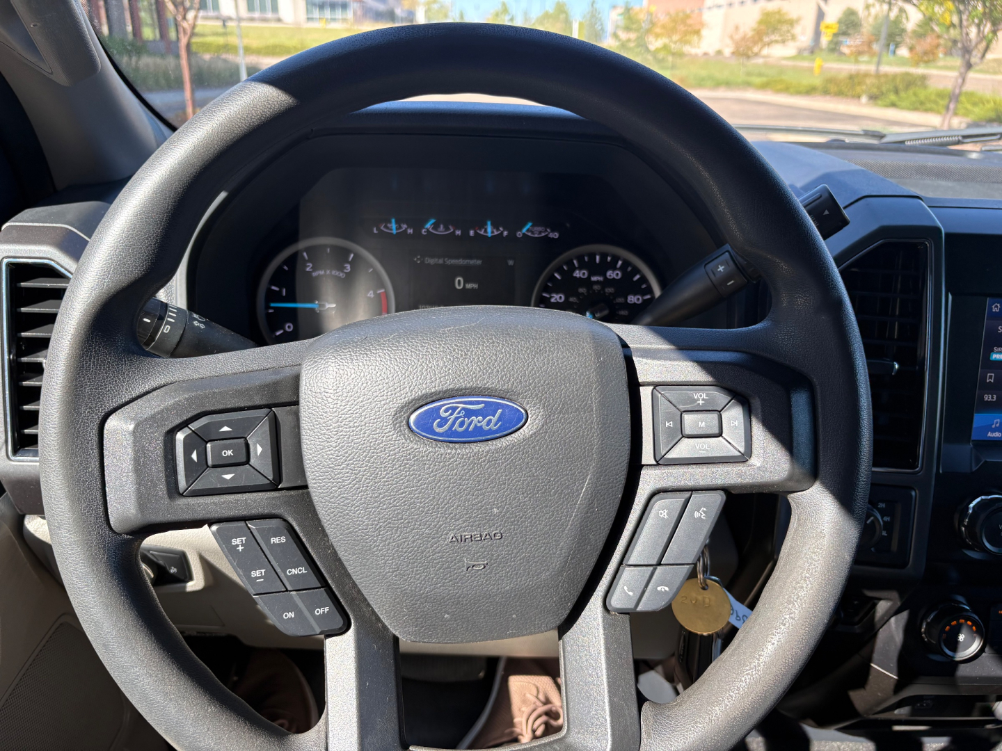 Ford steering wheel and dashboard view inside a 2022 Ford F-550 box truck showing steering wheel controls and dash gauges.