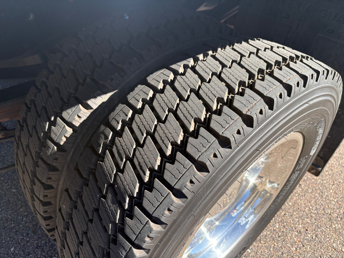 Ford F-550 dual rear wheels showing heavy tread tires and chrome wheel in close-up view