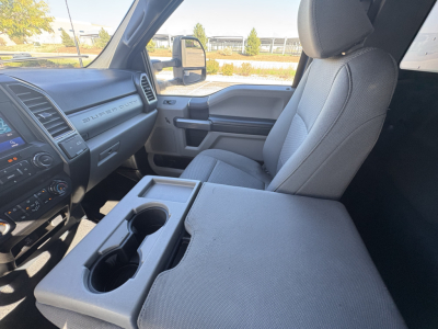 Ford F-550 interior driver and front passenger seat with center console and cup holders visible.