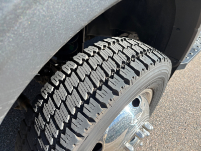 Ford F-550 wheel and tire close-up showing rugged tread pattern and wheel hub in front wheel well.
