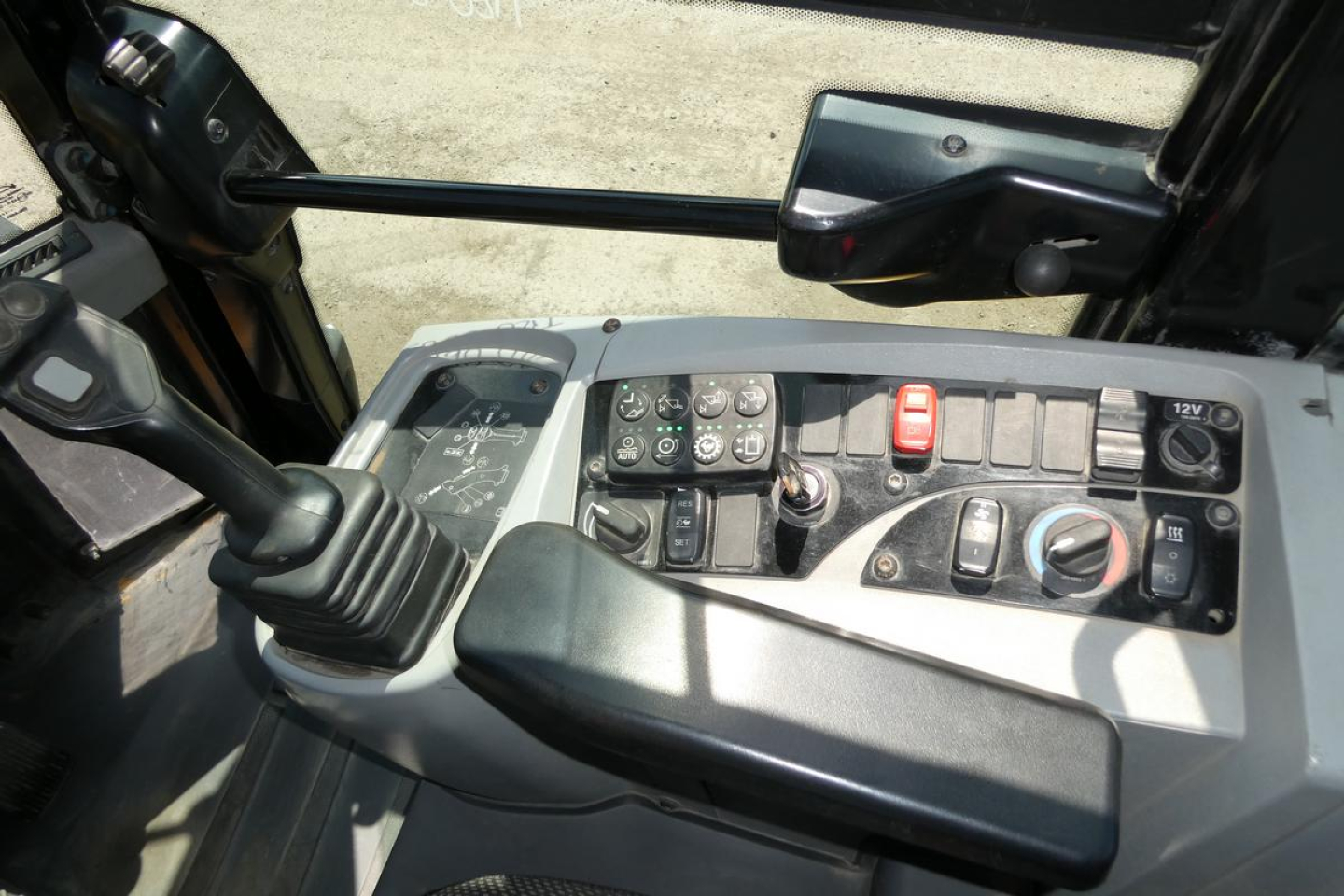 Operator cockpit of a Caterpillar 914 wheel loader showing joystick, control panel with multiple switches, gauges, and levers.