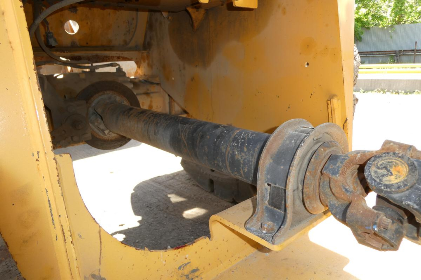 Caterpillar 914 wheel loader linkage driveshaft and hydraulic components visible in the engine bay area.