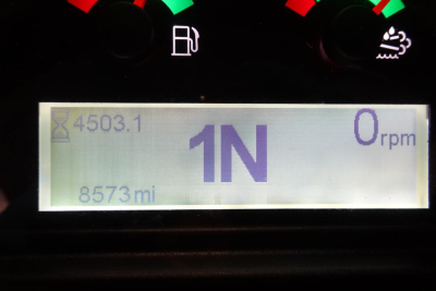 Displays panel from Caterpillar 914 wheel loader showing 1N gear indicator, 0 rpm, fuel and warning icons, odometer 8573 miles and cycle count 4503.1 on screen.