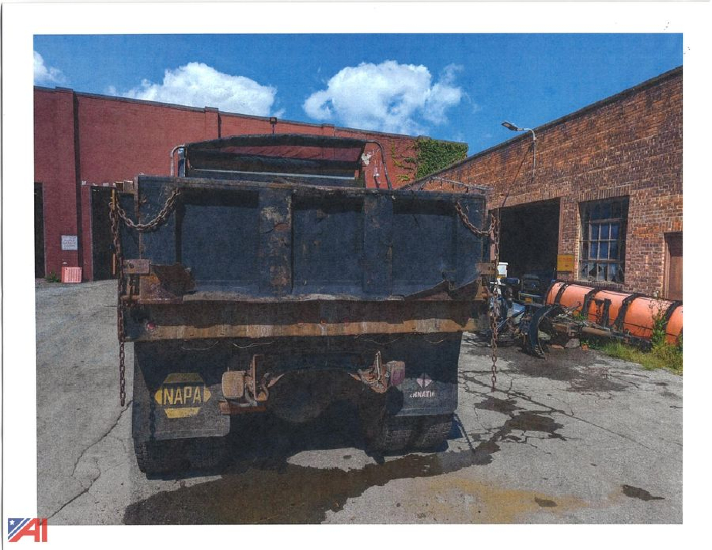 Dump truck rear view showing cargo bed with chains, NAPA sticker, and taillight area; 1986 International 1954 Cab 68ABC listing context.