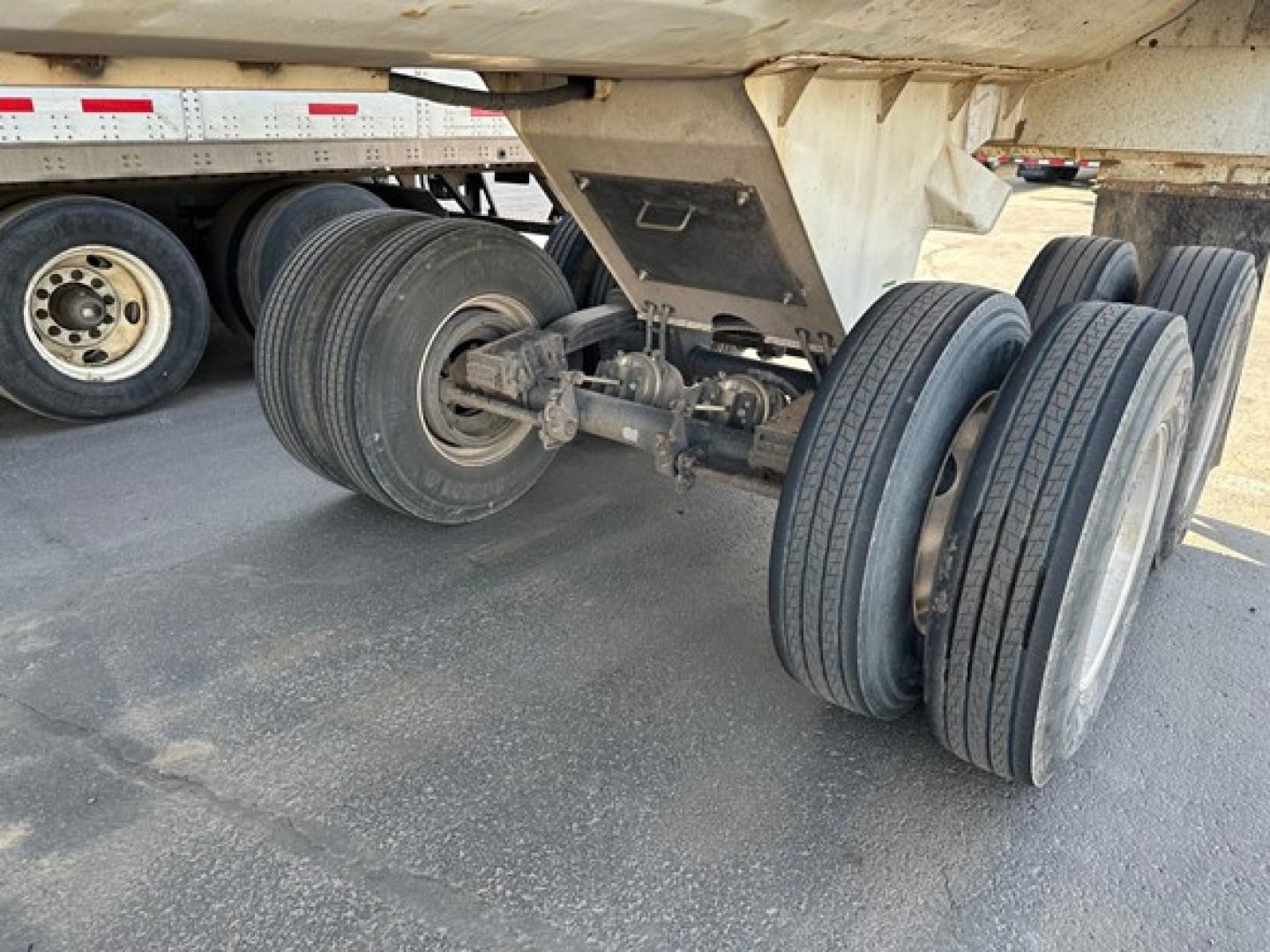 Load King frameless rock end dump trailer showing dual-axle landing gear and multiple tires under the trailer bed.