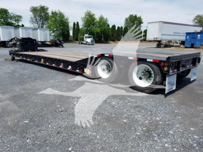 Lowboy trailer 35Gsl- Pt showing dual rear axles and long bed with reflective tape and signage.