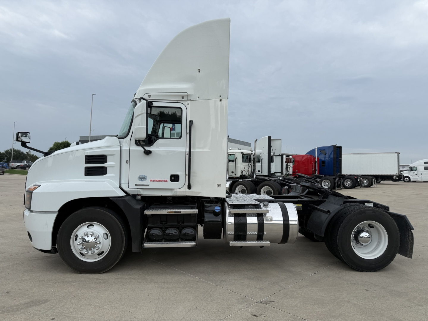 Truck side view of a 2022 Mack AN42T day cab showing fuel tanks, chassis, and cab; no visible labeling legible on cab panels in this shot.