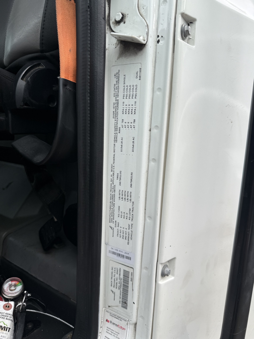 Mack AN42T cab interior door area showing a red and white label with VIN and specs on the door jamb.