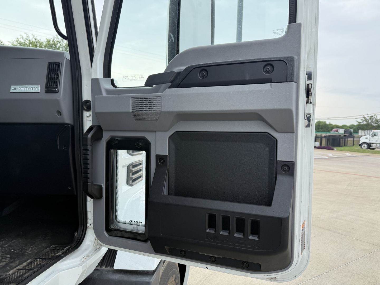 Truck cab interior door panel showing storage pockets and control panel in a Mack AN42T daycab.