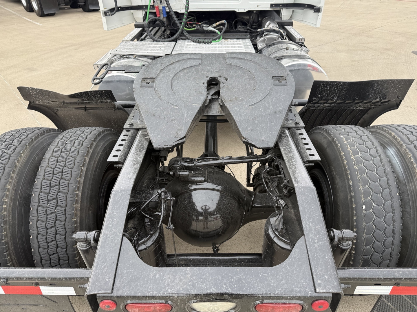 Tractor trailer fifth wheel area and rear axle of a 2022 Mack AN42T daycab showing dual rear wheels and drive axle housing.