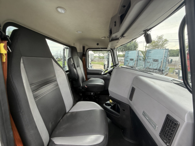 Cab interior of a 2022 Mack AN42T daycab showing seating and dashboard with a badge reading 'MACK' and other controls.