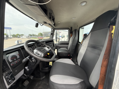 Mack AN42T dash and driver seat view showing steering wheel, instrument cluster, and front seats inside cab.
