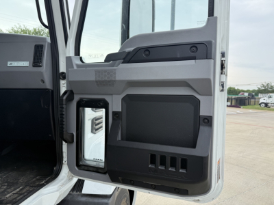 Truck cab interior door panel showing storage pockets and control panel in a Mack AN42T daycab.