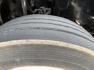 Trailer/drive axle with dual tires and tread detail in front view under Mack AN42T cab showing tire sidewall markings.