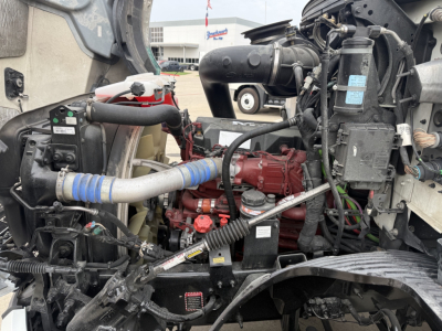 Mack AN42T engine bay showing red engine block, coolant hoses, and various labels in view through cab opening.