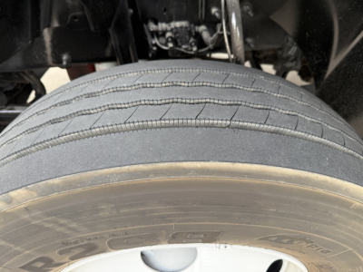 Tire close-up on Mack AN42T cab-over truck showing tread detail and wheel hub.