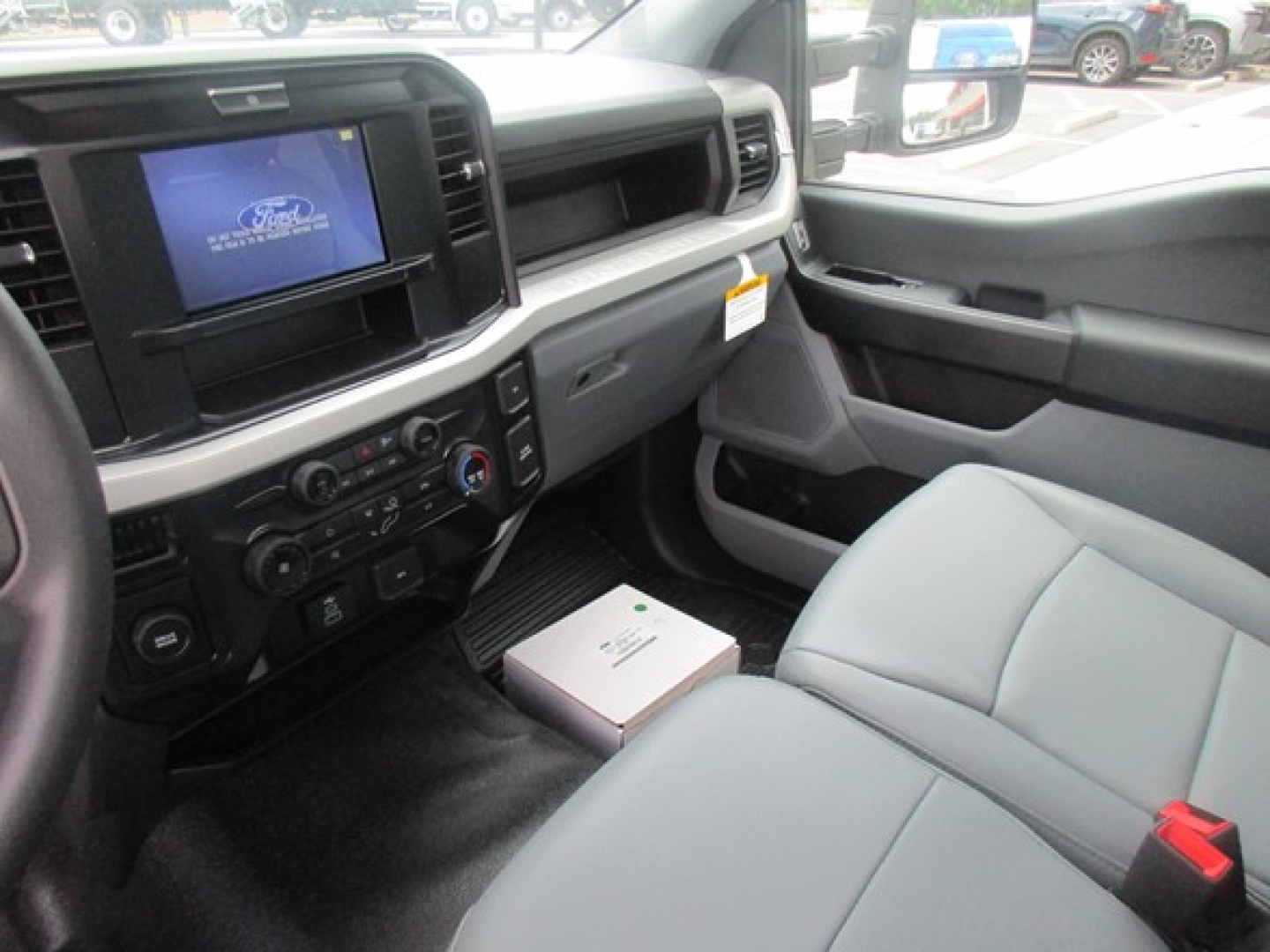 Ford F-550 cab interior showing dashboard with touchscreen, climate controls, and gray seats.