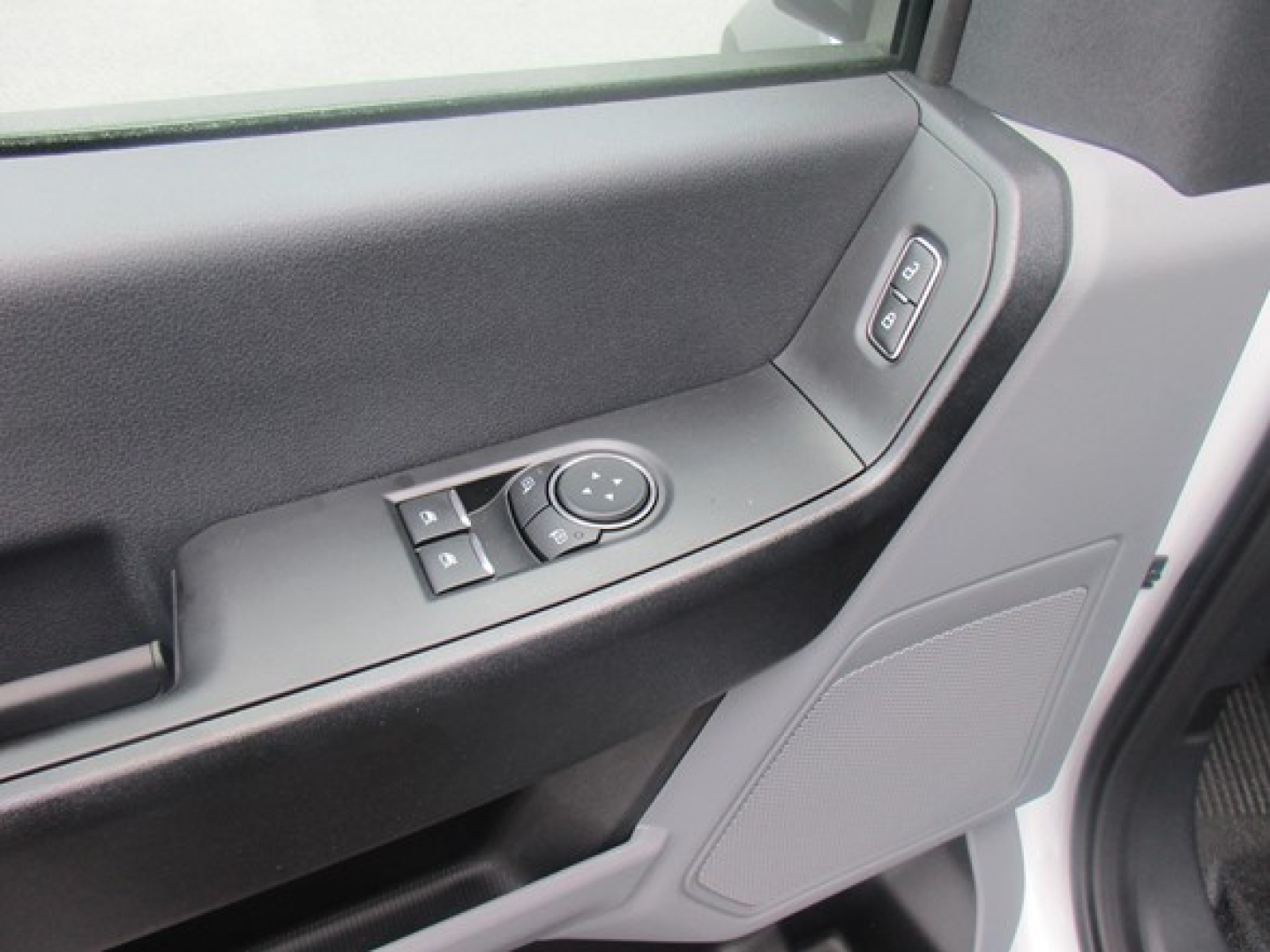 Door panel view inside a 2025 Ford F550 XL truck showing power window lock controls and speaker grille.