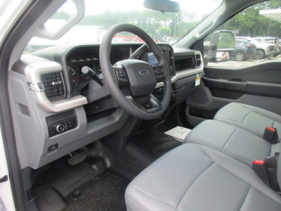 Ford F-550 interior cabin with steering wheel, gauges, and gray seats seen from driver side.