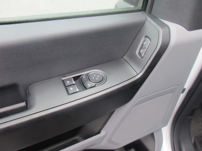 Door panel view inside a 2025 Ford F550 XL truck showing power window lock controls and speaker grille.