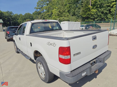 2005 Ford F-150 extended cab pickup truck rear and left-side view showing 4x4 badge, bed area, tailgate and Ford emblem.