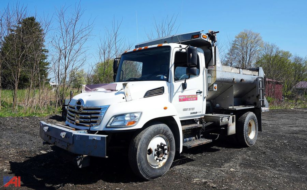 Dump truck showing 2010 Hino 338 4x2 all-season dump body with front bumper and dual rear wheels.