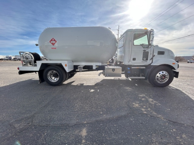 Truck side view showing a new 2026 Mack MD7 with a large cylindrical tank and dual rear wheels.