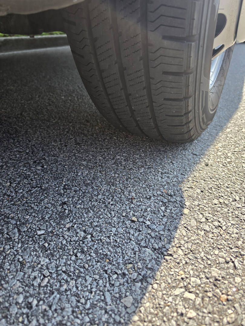 Wheel and ground view of a Ford Transit 350 HD showing tire tread and pavement.