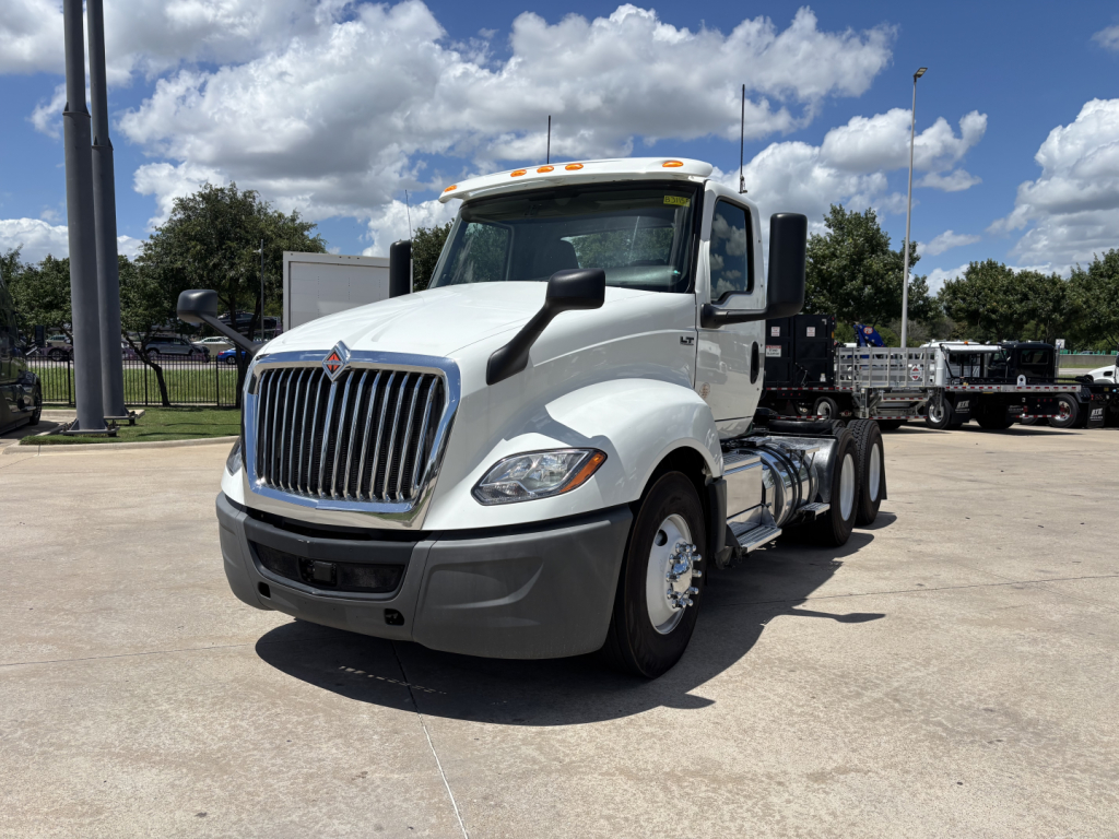 International LT semi-truck cab showing front grille and side view with white cab and black mirrors.