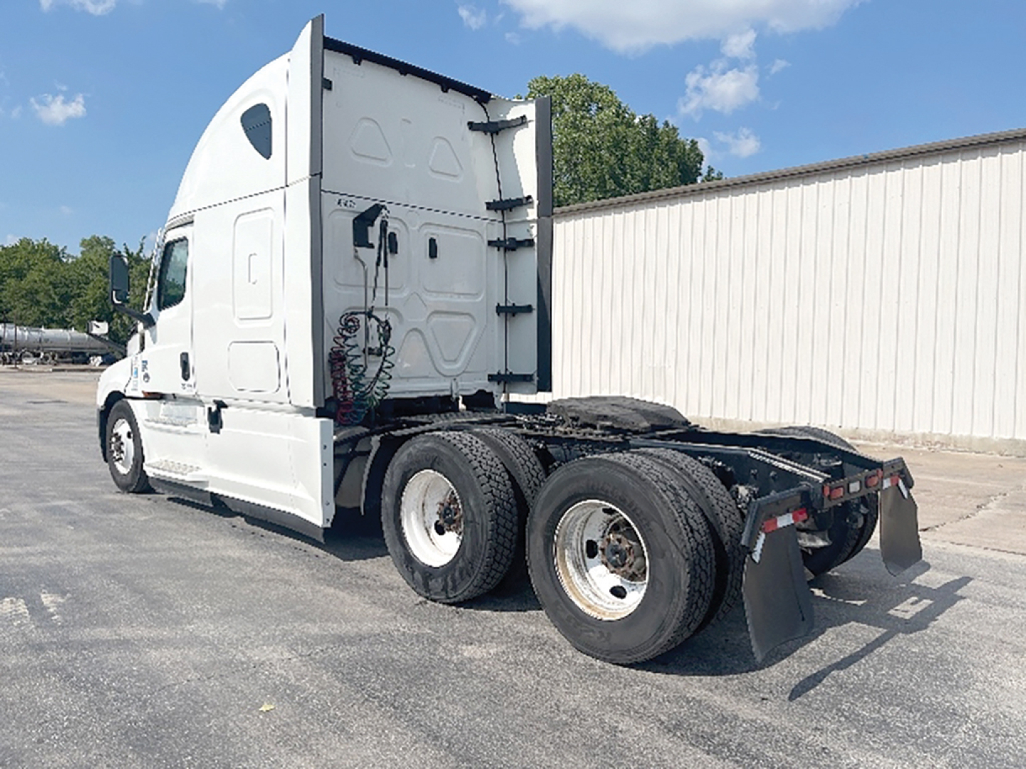 Side view of a 2022 Freightliner Cascadia126 tractor with sleeper cab, showing rear wheel assembly and chassis.
