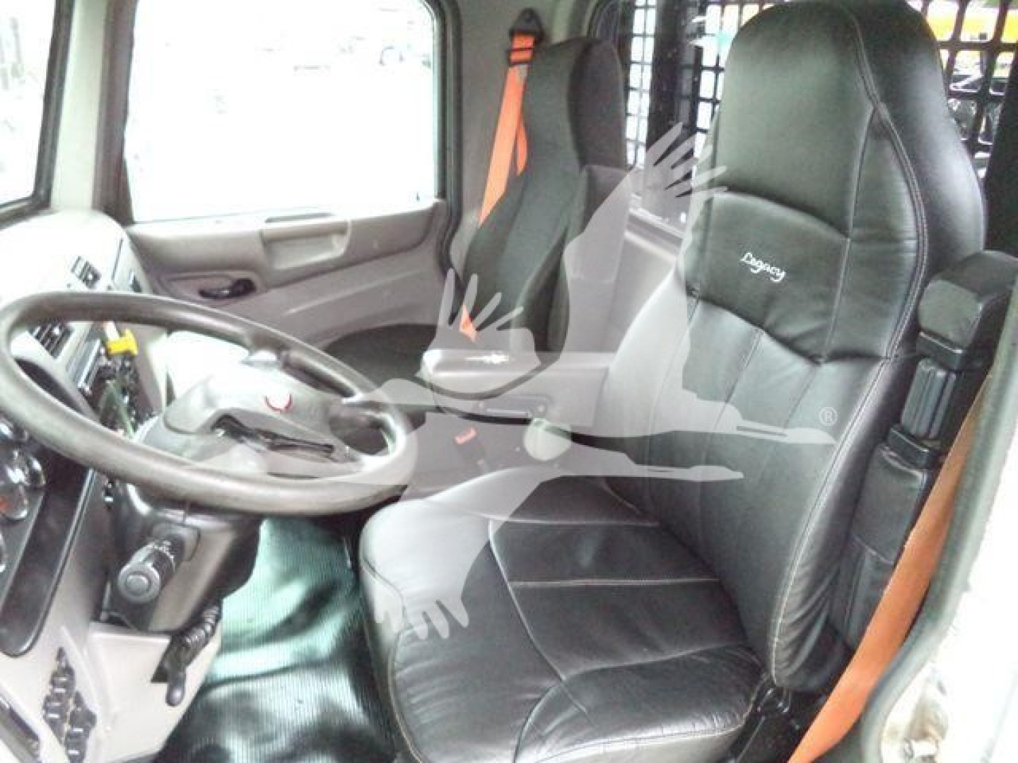 Truck cab interior of a 2018 Peterbilt 348 showing the driver seat with 'Inspire' style stitching, dashboard, steering wheel, and side door area.