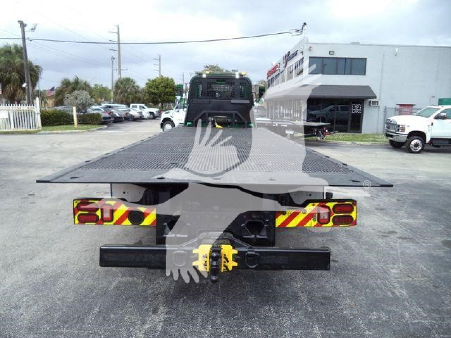 Truck rollback bed viewed from rear showing towing hitch and reflective decals, 2018 Peterbilt 348, outdoor lot.