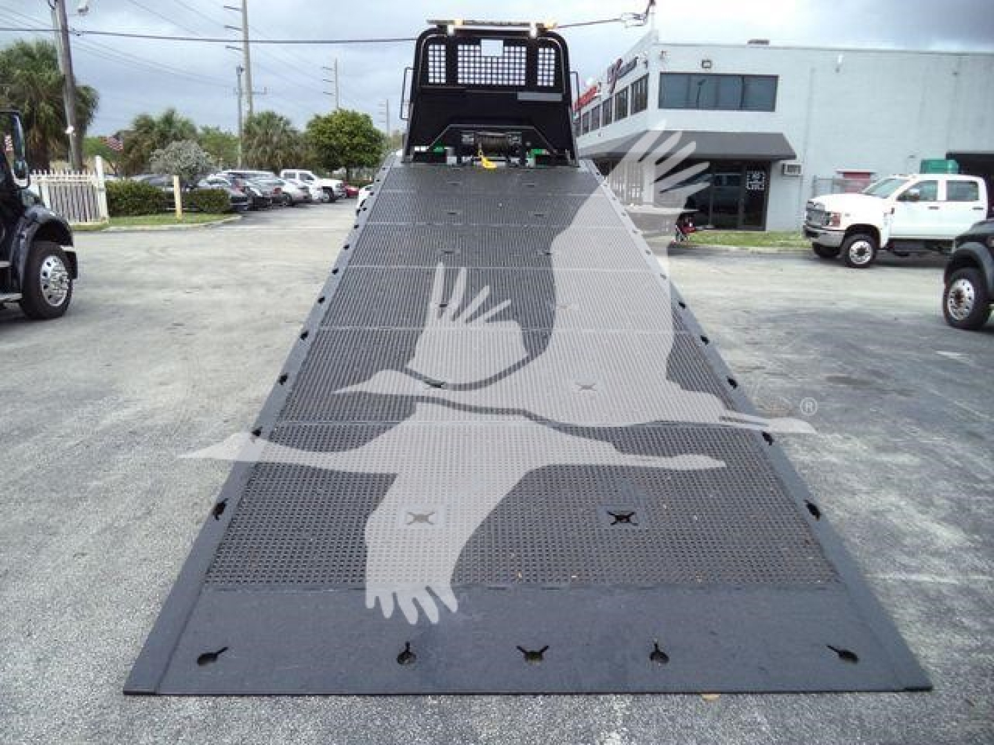 Peterbilt 348 rollback truck bed ramp with perforated metal surface and rear loading area, gear and grille visible at the top.