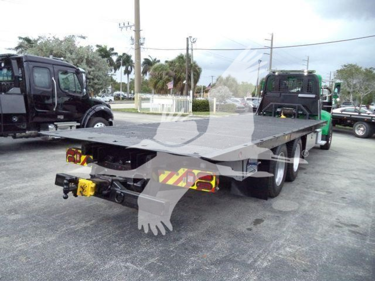 Peterbilt 348 rollback flatbed tow truck showing rear view with twin rear axles and platform.