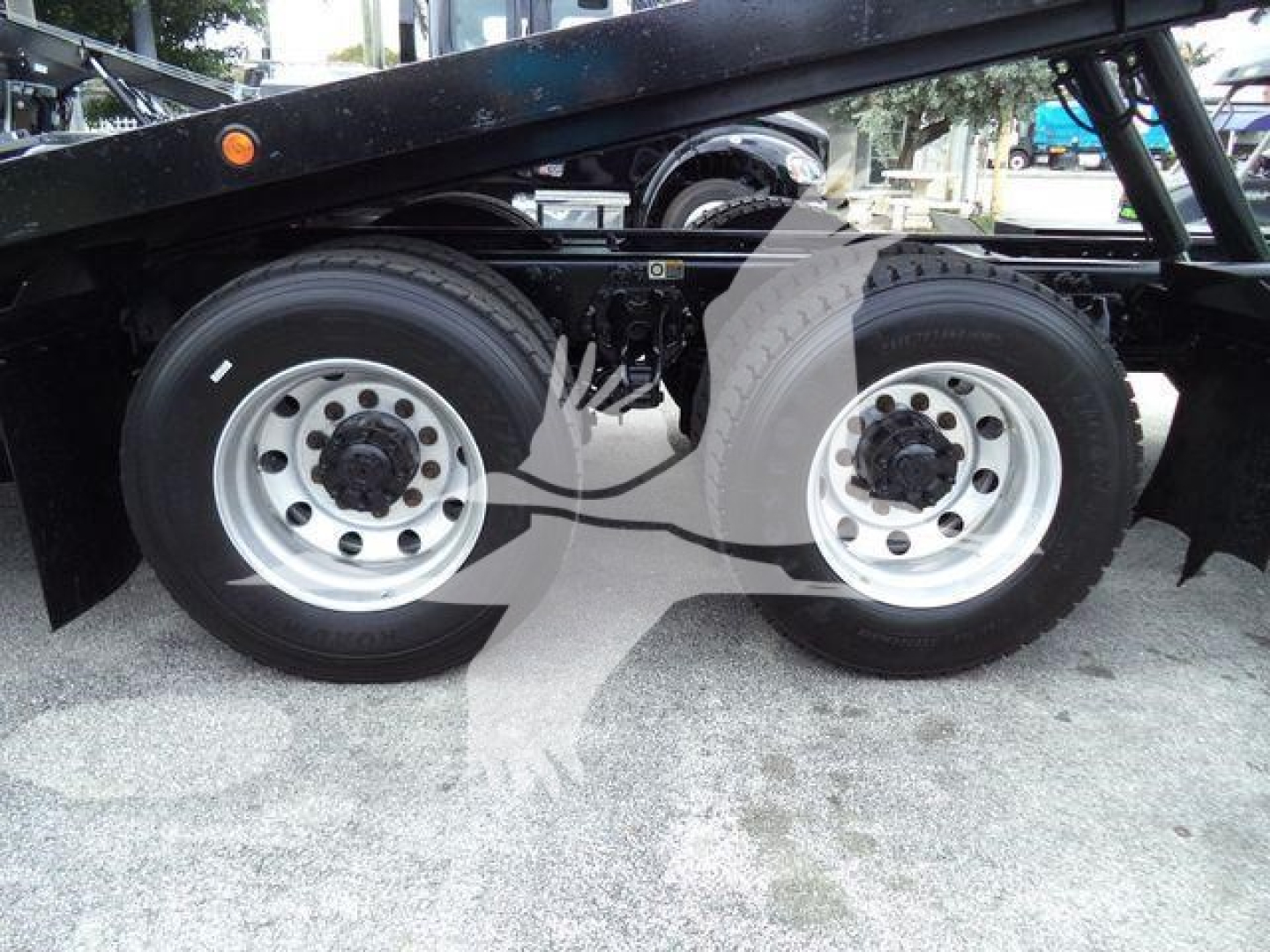 Dual rear axles of a Peterbilt 348 rollback truck showing two rear wheels and frame members.