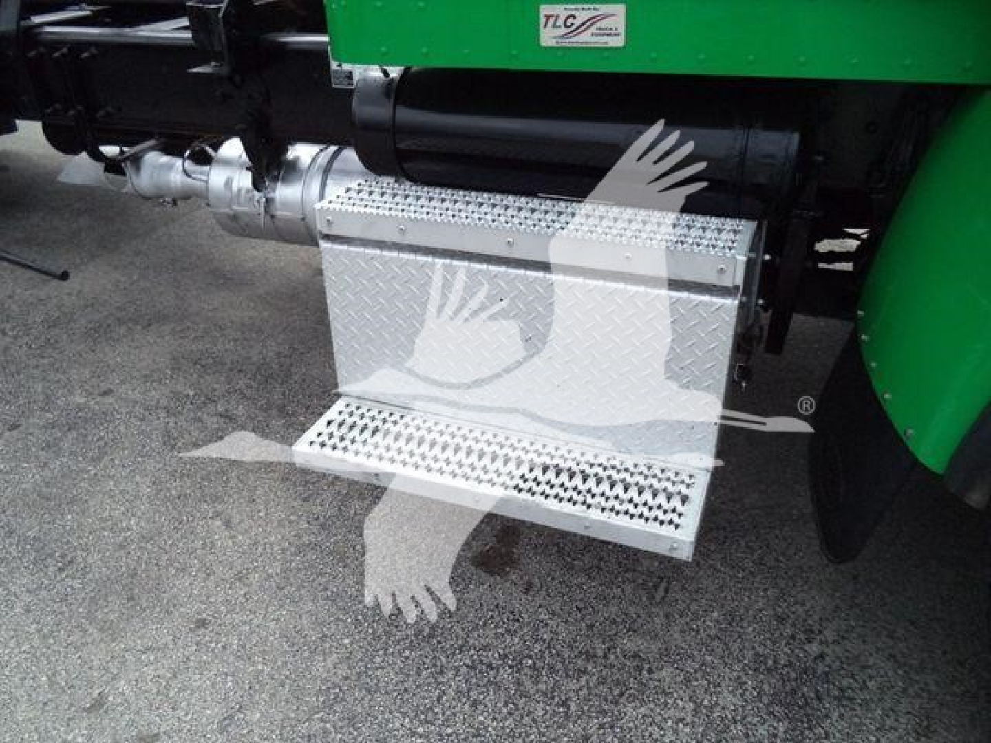 Peterbilt 348 rollback truck steps aluminum diamond plate with green body and chrome fuel line visible.