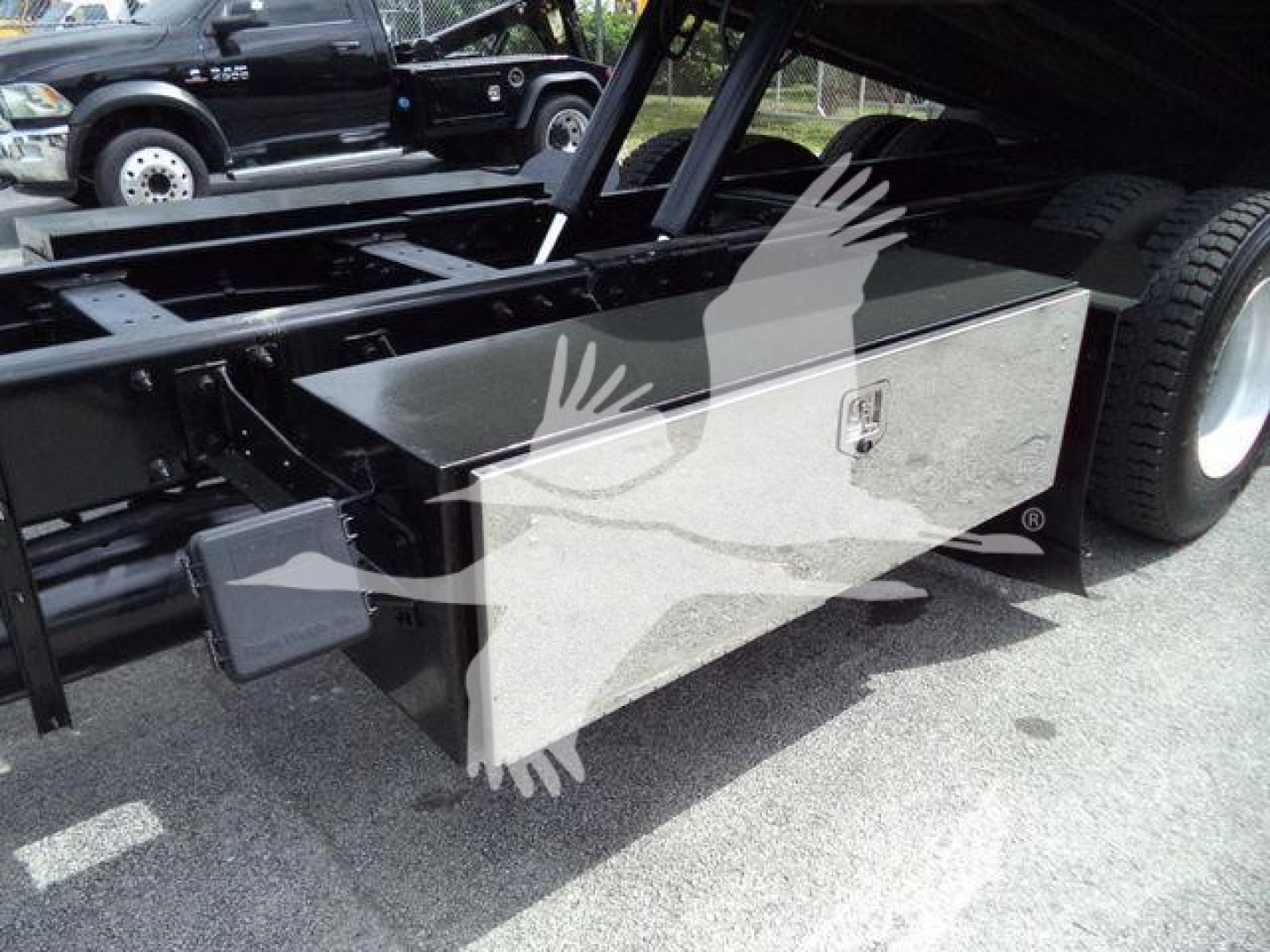 Peterbilt 348 rollback chassis with aluminum toolbox mounted between frame rails showing rectangular toolbox with latch and side step area.